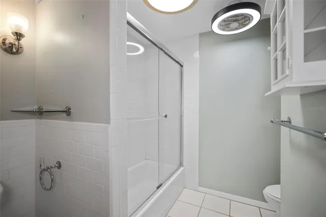 a bathroom with a granite countertop bathtub shower and toilet