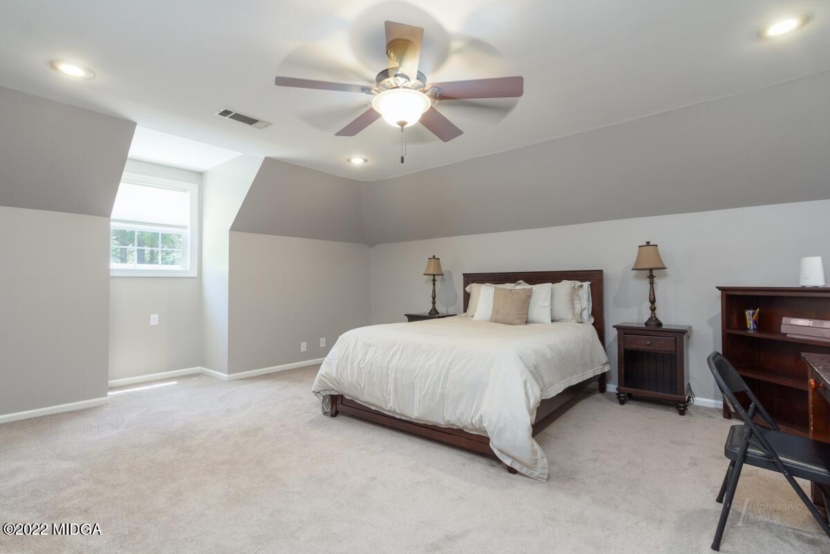 331 Country Creek Road Macon, GA 31220 - Photo 18 of 36 a spacious bedroom with a bed and a chandelier