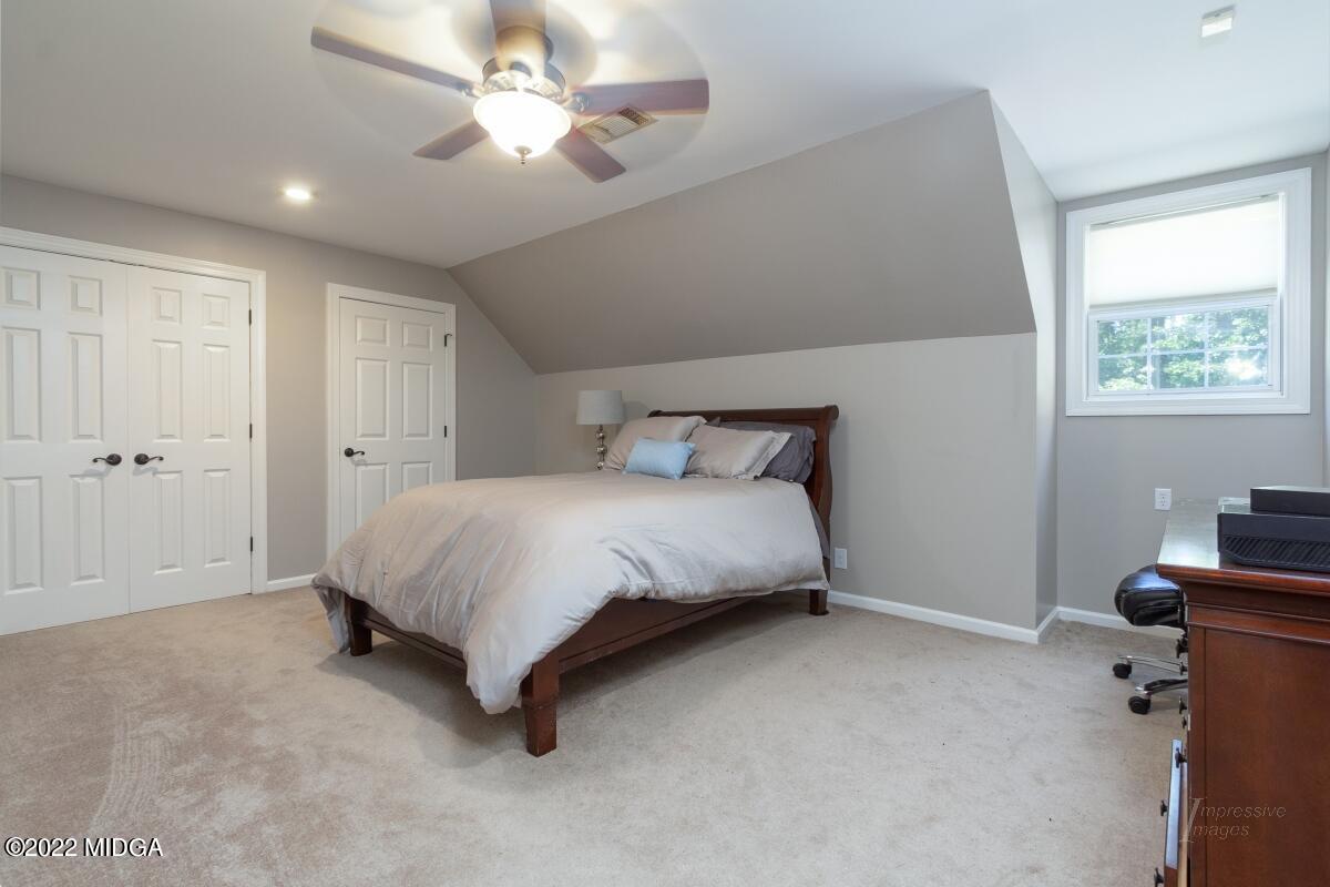 331 Country Creek Road Macon, GA 31220 - Photo 19 of 36 a spacious bedroom with a bed and a chandelier