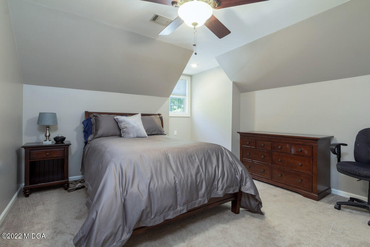 331 Country Creek Road Macon, GA 31220 - Photo 20 of 36 a bedroom with a bed and a chandelier