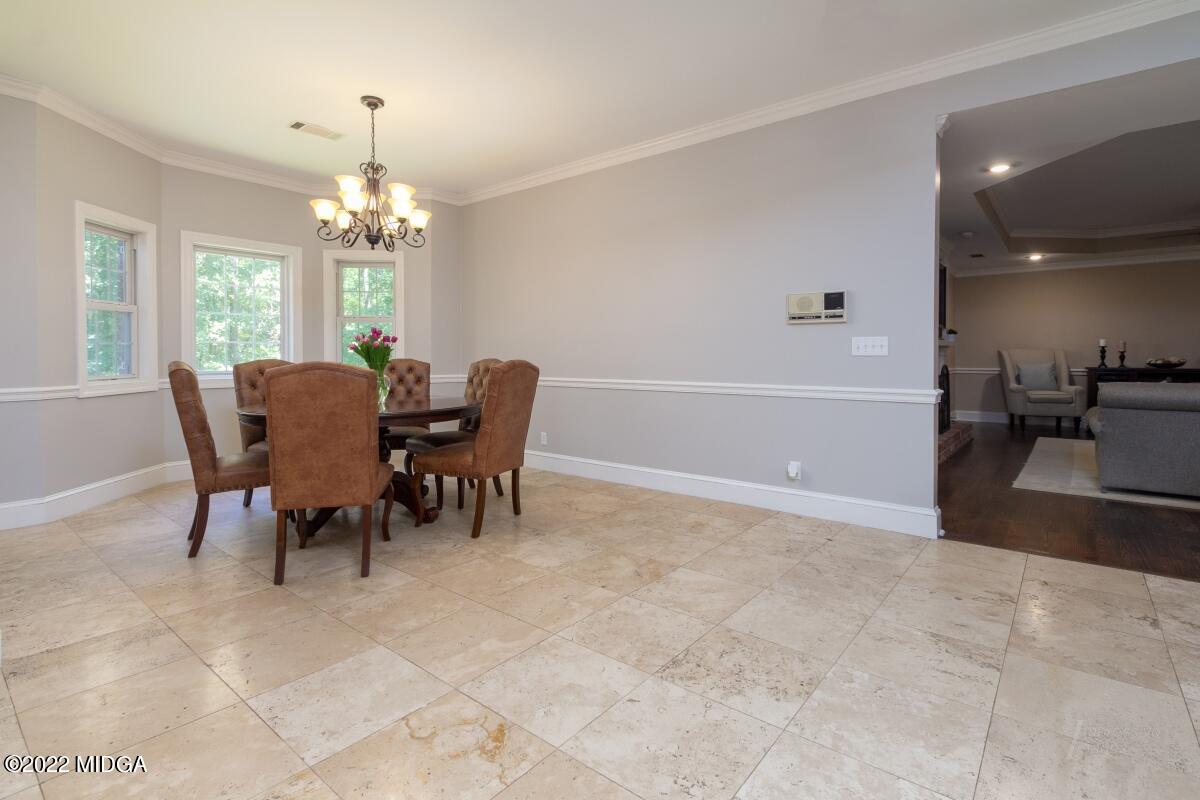 331 Country Creek Road Macon, GA 31220 - Photo 8 of 36 a view of a dining room with furniture a chandelier and wooden floor