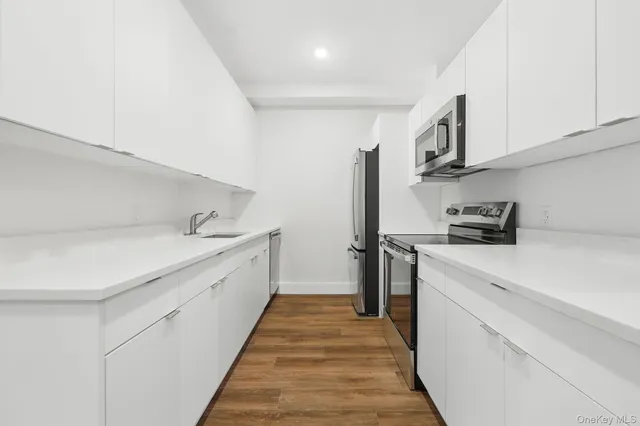 a kitchen with white cabinets and sink
