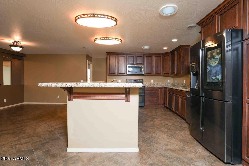 4330 East Navajo Lane Rimrock, AZ 86335 - Photo 17 of 59 a kitchen with stainless steel appliances granite countertop a sink counter space cabinets and a large window