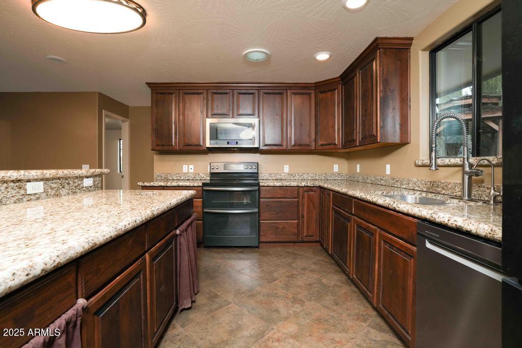 4330 East Navajo Lane Rimrock, AZ 86335 - Photo 18 of 59 a kitchen with stainless steel appliances granite countertop a sink stove and cabinets