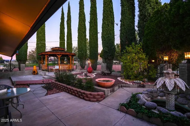 a backyard of a house with barbeque oven table and chairs