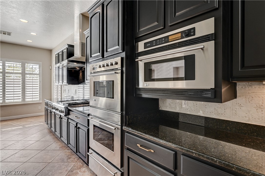 2793 Rosenhearty Drive Henderson, NV 89044 - Photo 8 of 85 This kitchen showcases a well-appointed cooking space with extensive cabinetry and modern appliances.