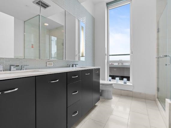 2 2nd Street, Unit 4001 Jersey City, NJ 07302 - Photo 14 of 31 a bathroom with a sink vanity and mirror