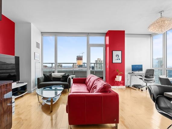 2 2nd Street, Unit 4001 Jersey City, NJ 07302 - Photo 3 of 31 a living room with furniture a fireplace and a flat screen tv