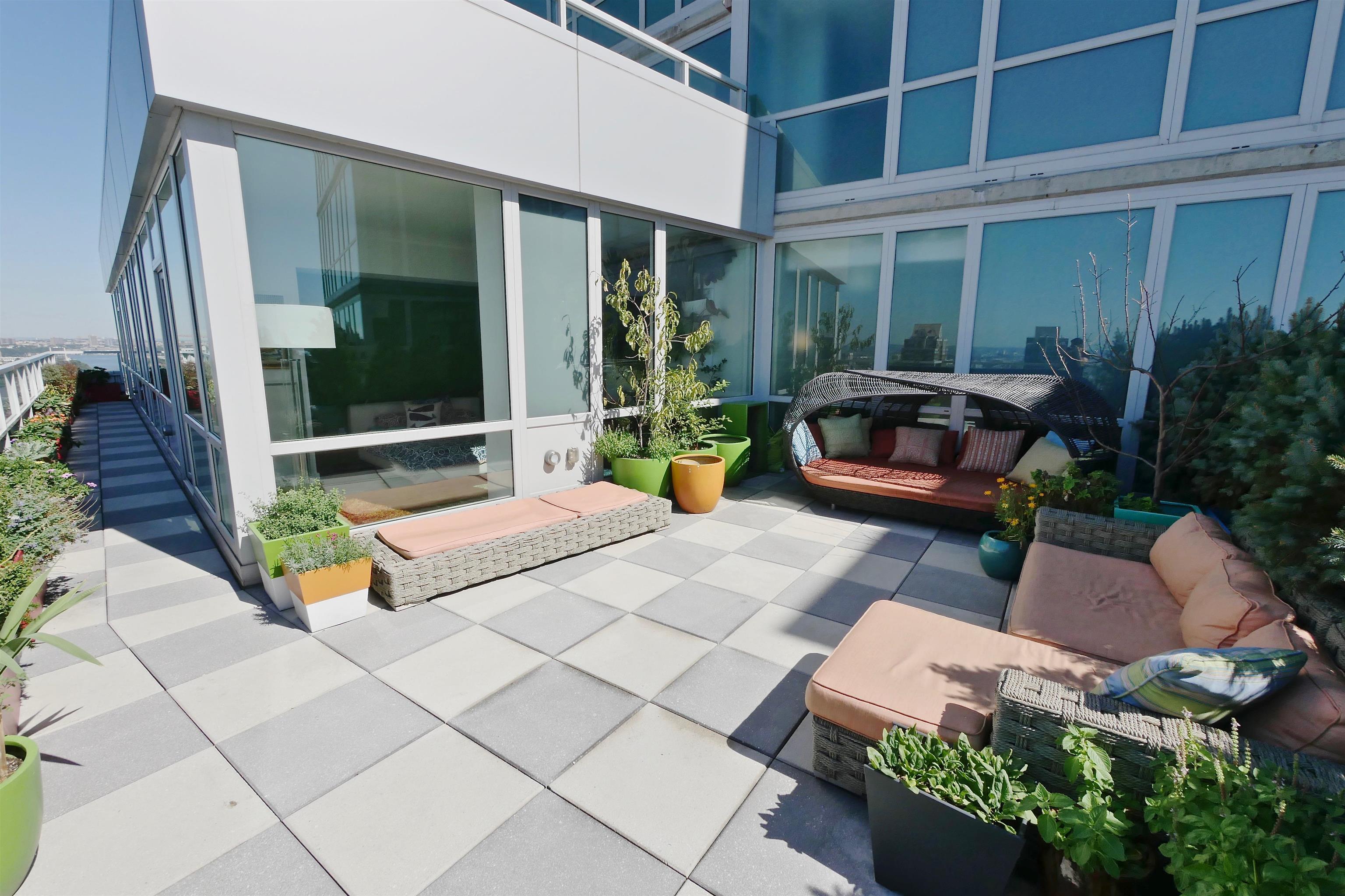 2 2nd Street, Unit 4001 Jersey City, NJ 07302 - Photo 5 of 31 a building outdoor space with patio furniture and potted plants
