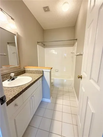 a bathroom with a granite countertop sink a mirror and a bathtub