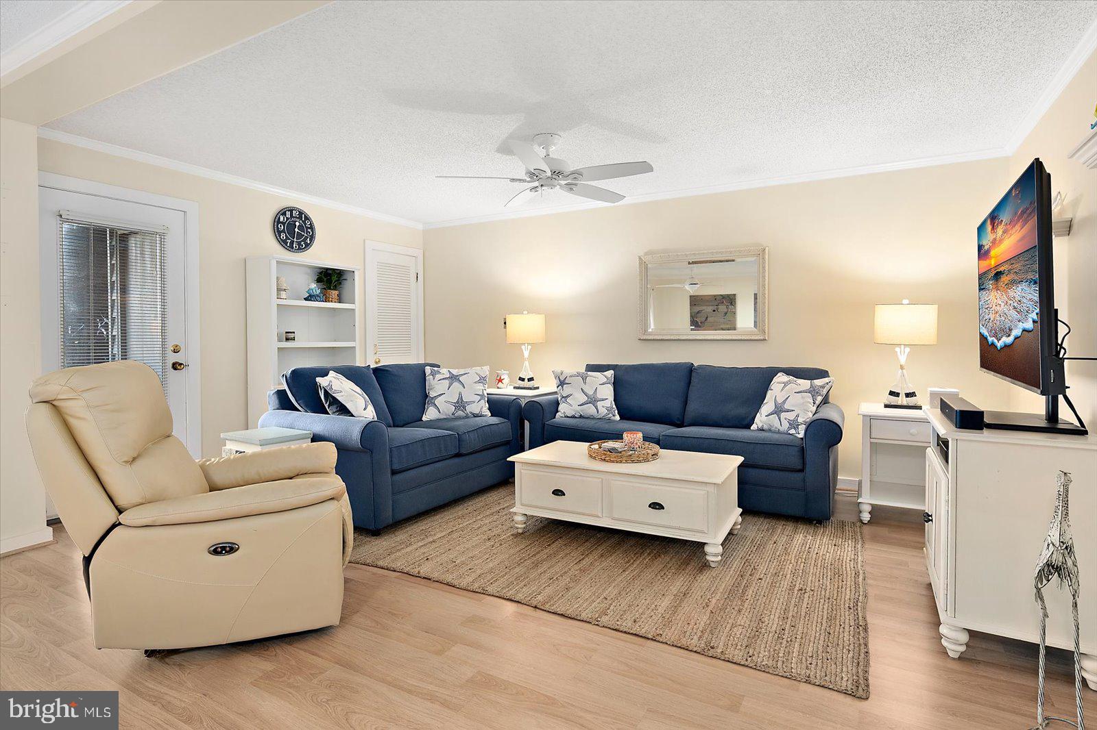 119 Old Landing Road, Unit 102A Ocean City, MD 21842 - Photo 12 of 47 a living room with furniture a flat screen tv and a fireplace