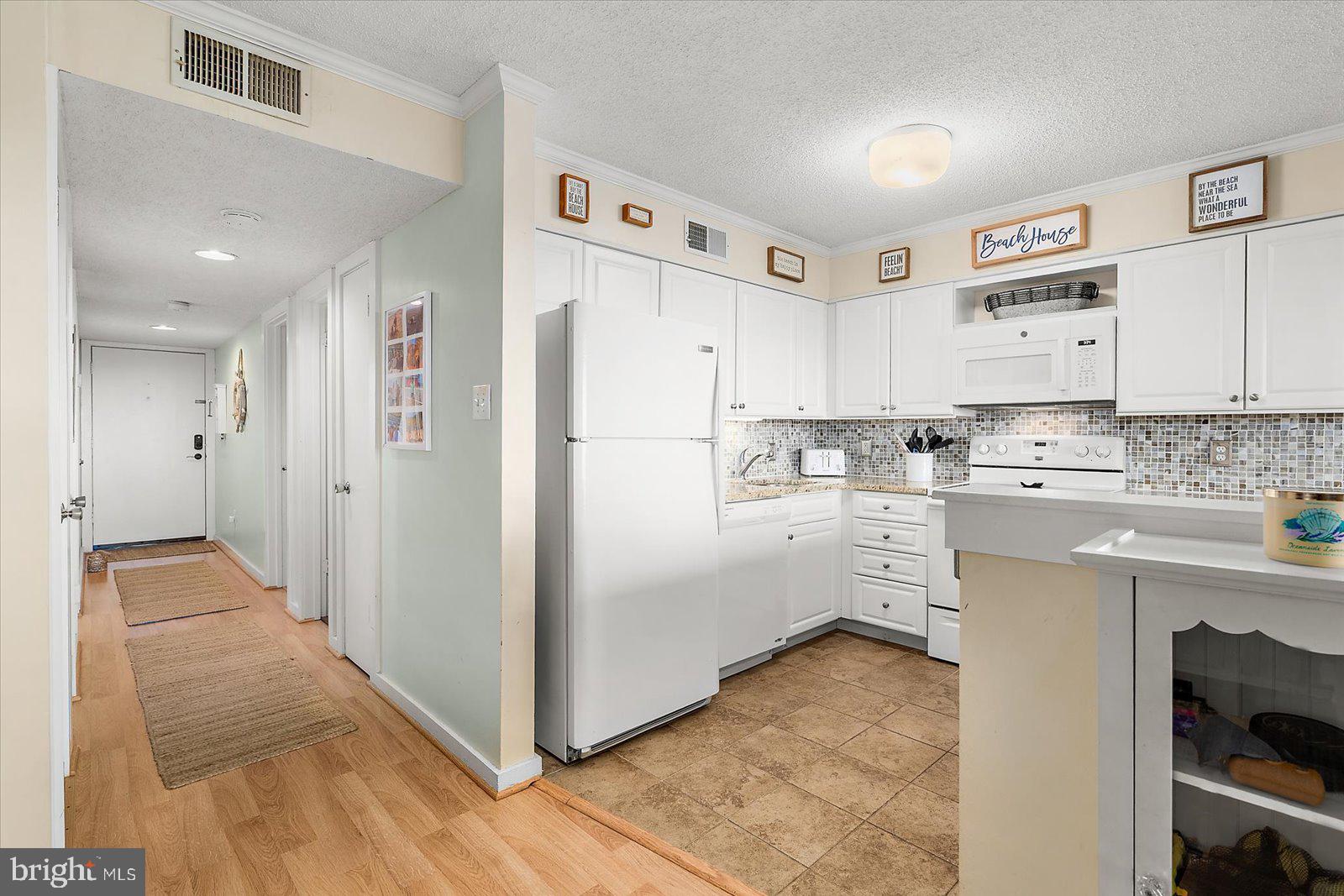 119 Old Landing Road, Unit 102A Ocean City, MD 21842 - Photo 17 of 47 a kitchen with white cabinets and white appliances