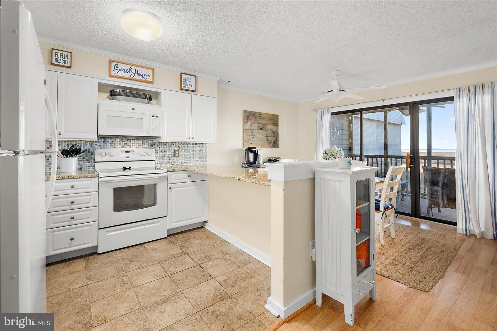 119 Old Landing Road, Unit 102A Ocean City, MD 21842 - Photo 20 of 47 a kitchen with white cabinets and white appliances