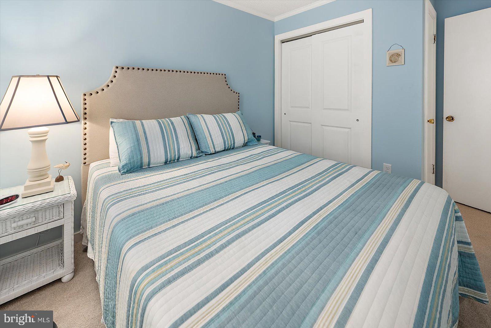 119 Old Landing Road, Unit 102A Ocean City, MD 21842 - Photo 28 of 47 a bedroom with a bed and a mirror