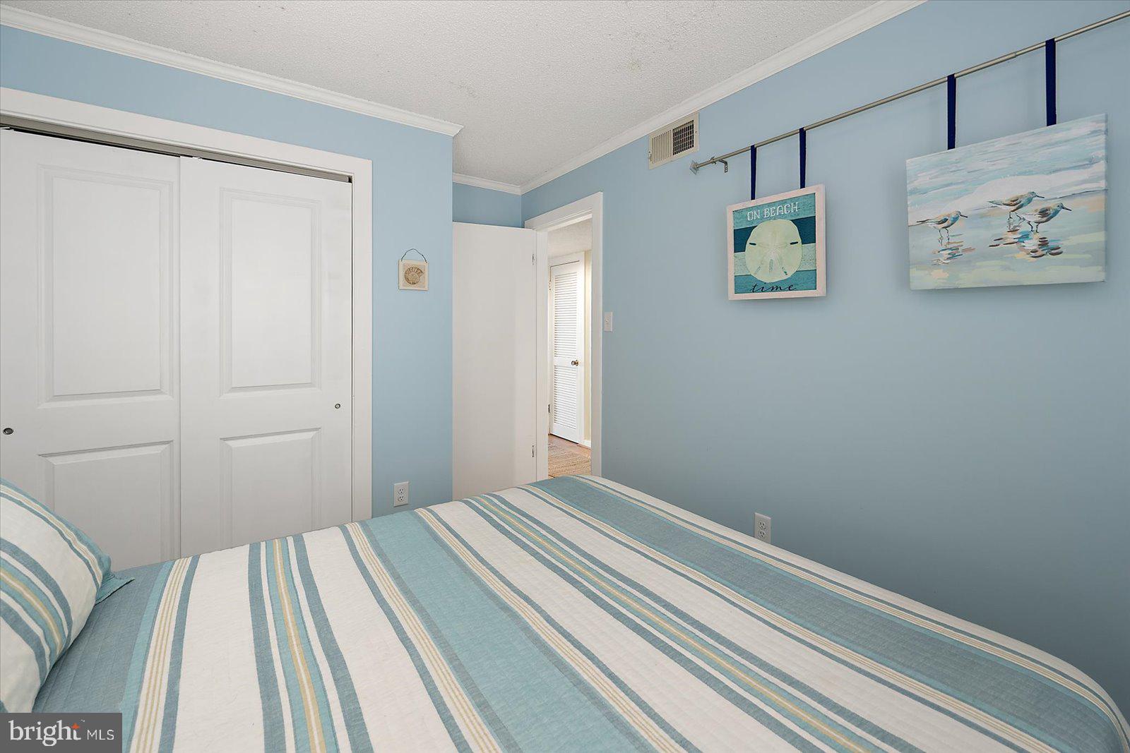 119 Old Landing Road, Unit 102A Ocean City, MD 21842 - Photo 29 of 47 a bedroom with a bed and painting on the wall