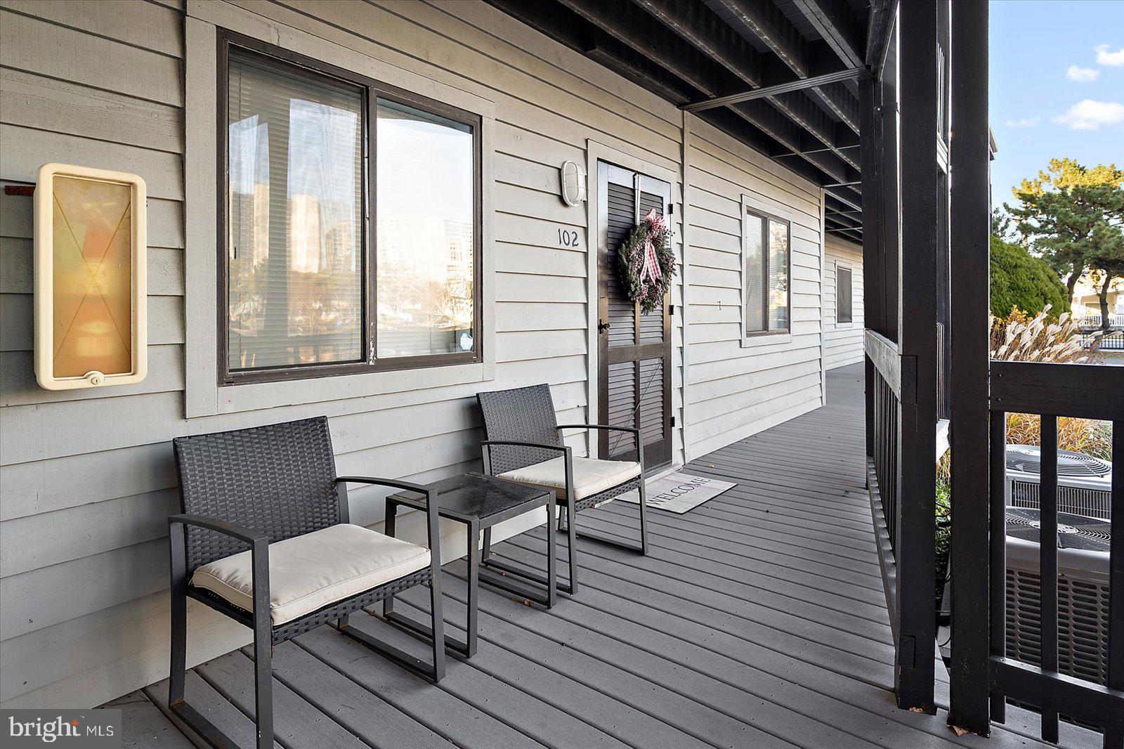 119 Old Landing Road, Unit 102A Ocean City, MD 21842 - Photo 38 of 47 a balcony with wooden floor table and chairs