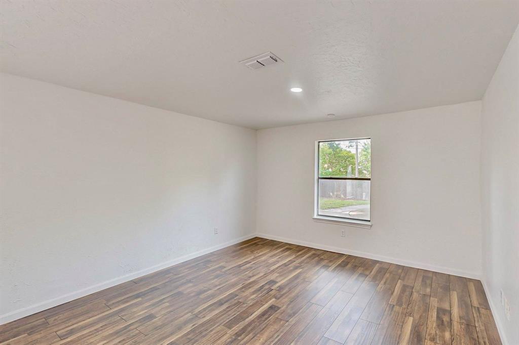 3965 Singleleaf Lane Fort Worth, TX 76133 - Photo 30 of 39 Interior room featuring wood-finish flooring, white painted walls, and a single window with white trim