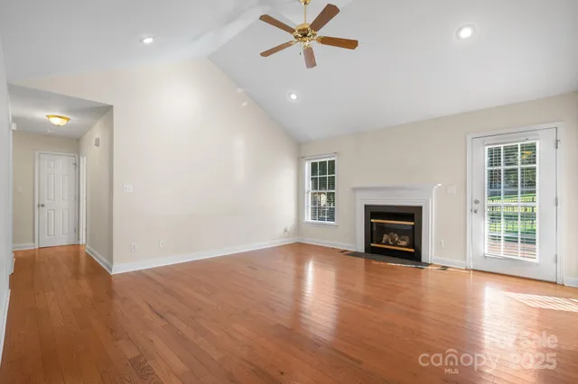 a view of empty room with wooden floor and fireplace