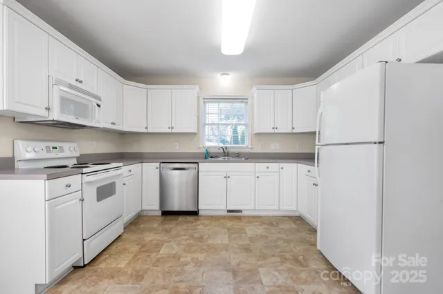 a kitchen with white cabinets and white appliances