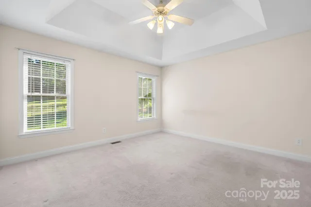 an empty room with a window and a ceiling fan