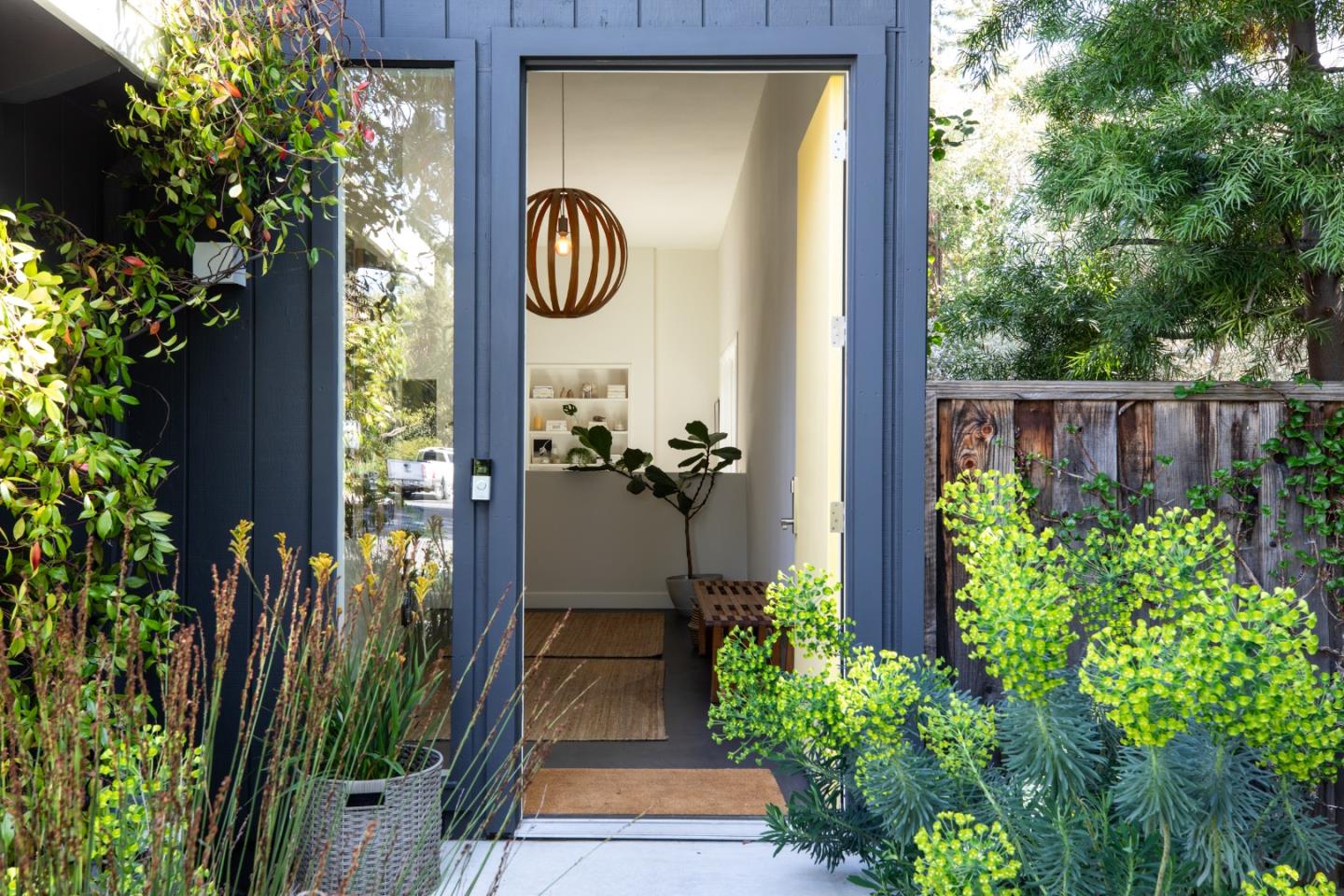 a front view of a house with a yard and potted plants