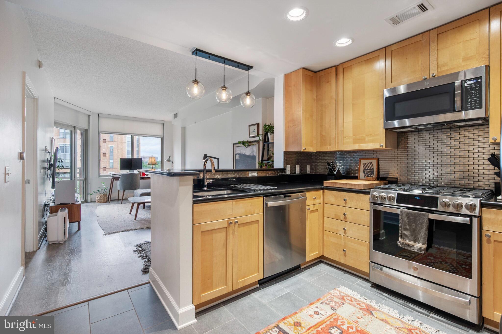 a kitchen with stainless steel appliances granite countertop a stove a sink and a microwave