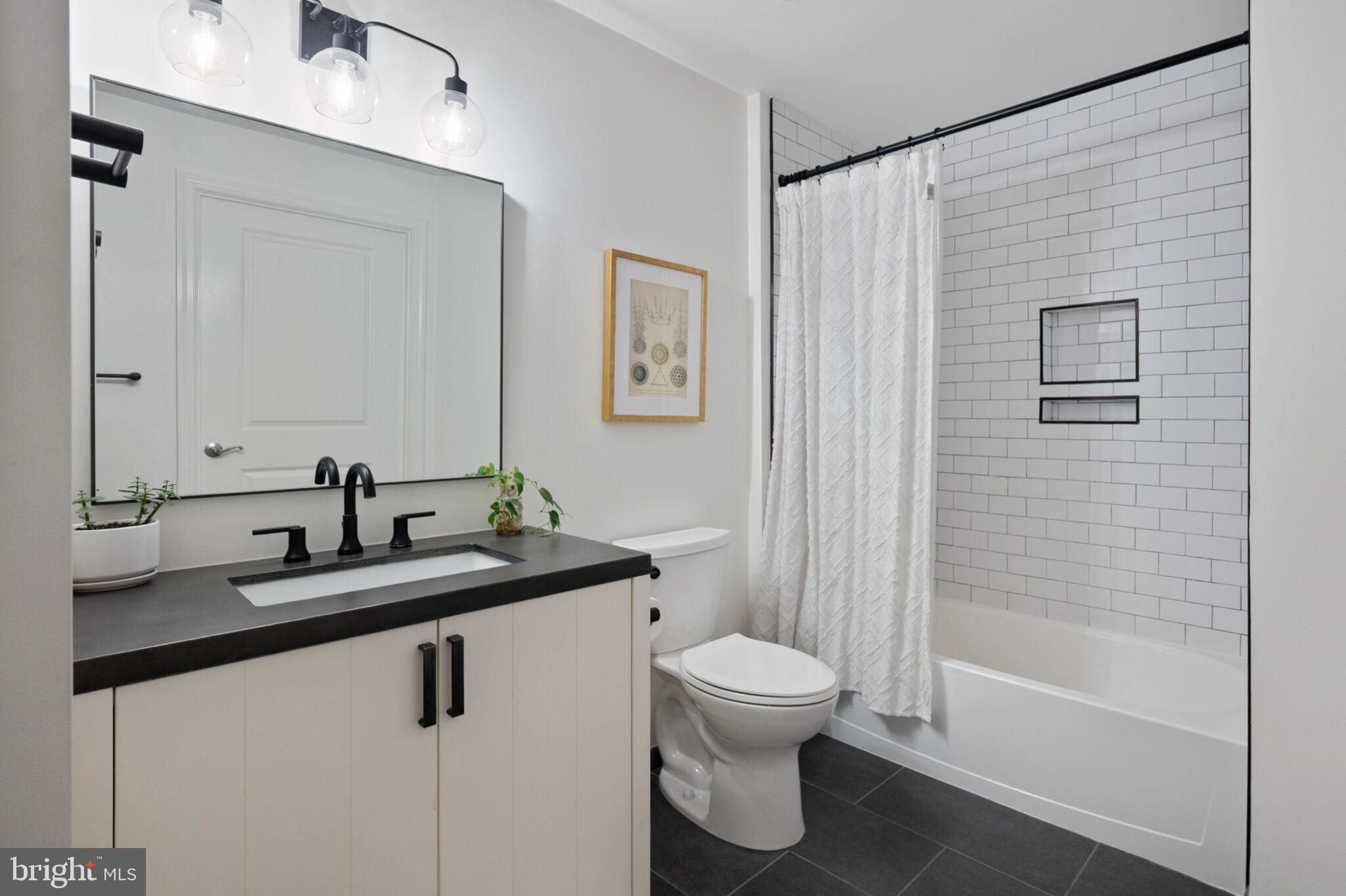 3650 South Glebe Road, Unit 450 Arlington, VA 22202 - Photo 18 of 60 a bathroom with a granite countertop sink a toilet and a bathtub