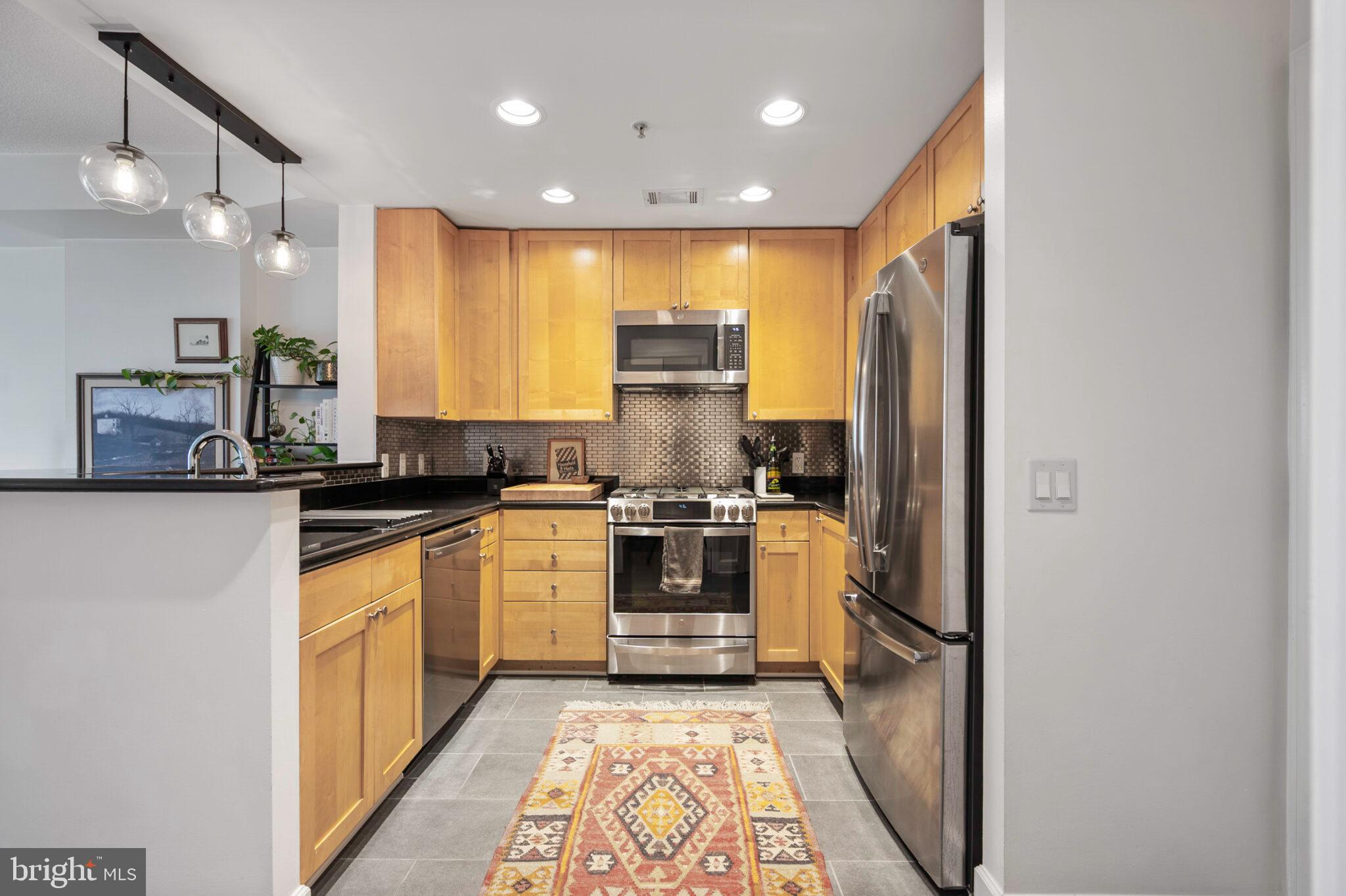 3650 South Glebe Road, Unit 450 Arlington, VA 22202 - Photo 6 of 60 a kitchen with stainless steel appliances granite countertop a stove a sink and a refrigerator