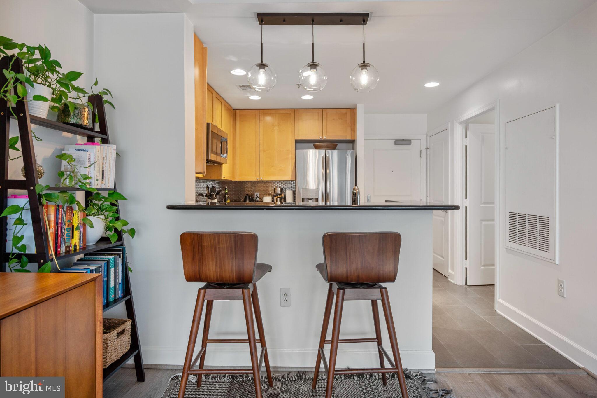 3650 South Glebe Road, Unit 450 Arlington, VA 22202 - Photo 9 of 60 a kitchen with stainless steel appliances granite countertop a table chairs and a refrigerator