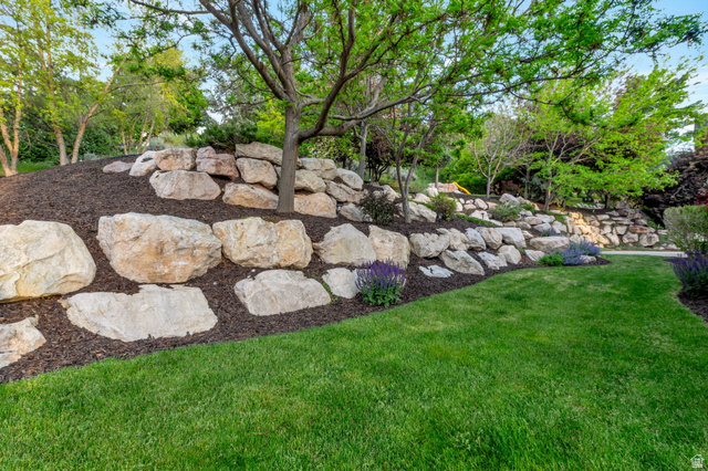577 South Ridge Top Lane East North Salt Lake, UT 84054 - Photo 50 of 57 Professionally designed landscaping showcases impressive natural boulder retaining walls, mature trees, and lush green lawn.