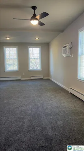 en empty room with windows and ceiling fan
