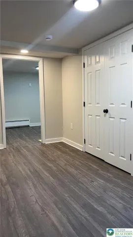 a view of an empty room with wooden floor