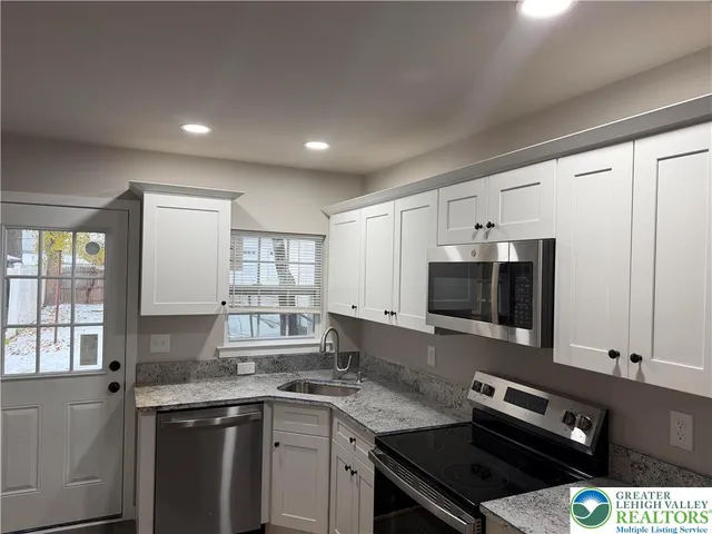 a kitchen with a sink stove and microwave