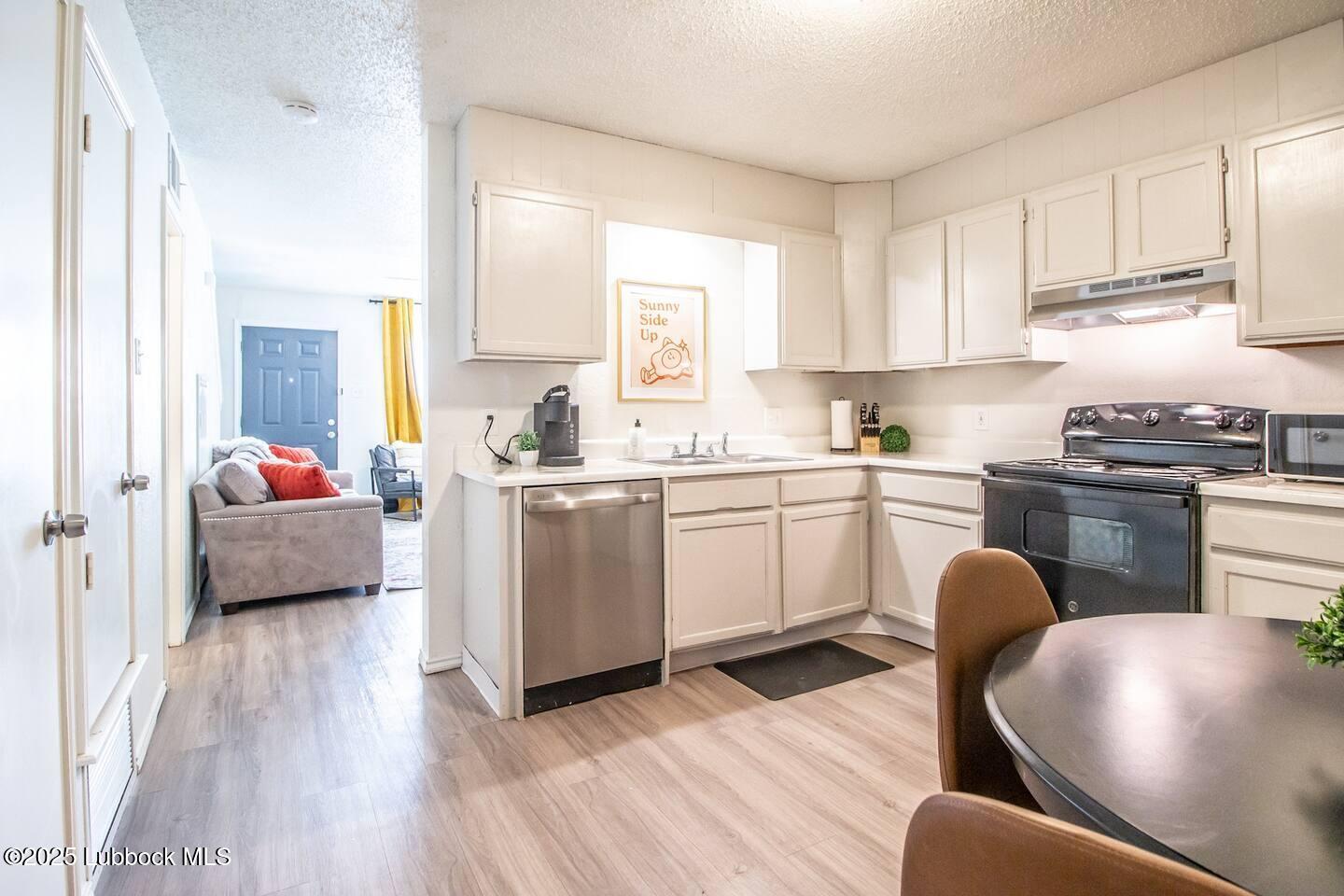 5806 6th Street, Unit B Lubbock, TX 79416 - Photo 6 of 45 a kitchen with a sink a stove cabinets and wooden floor