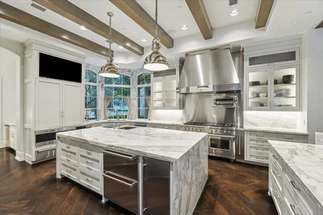 a kitchen with stainless steel appliances kitchen island granite countertop a stove and a sink