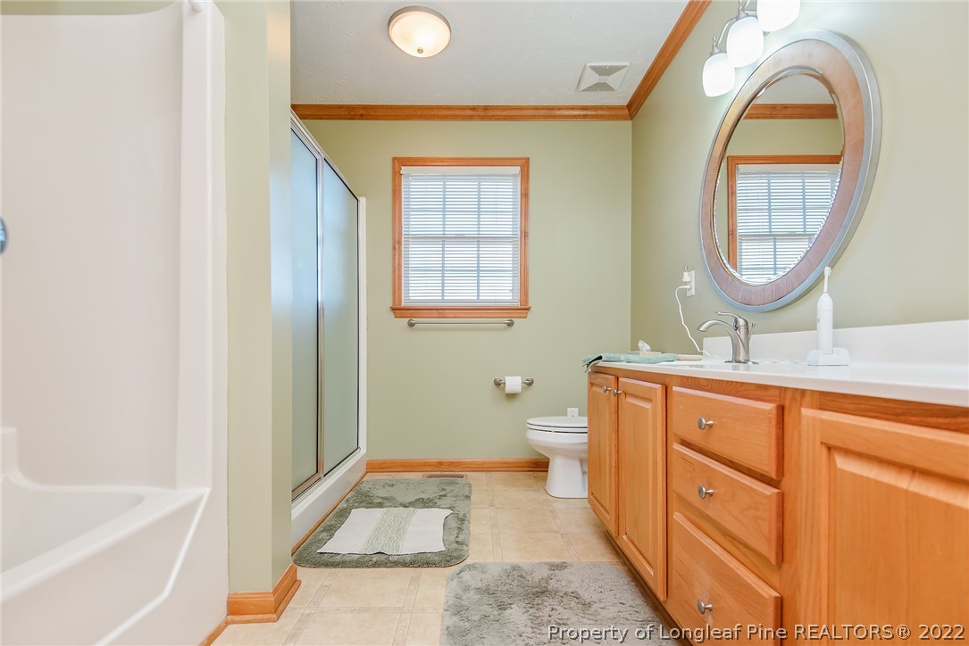 428 Rob Road Stedman, NC 28391 - Photo 22 of 45 a spacious bathroom with a sink a mirror a bathtub and a toilet
