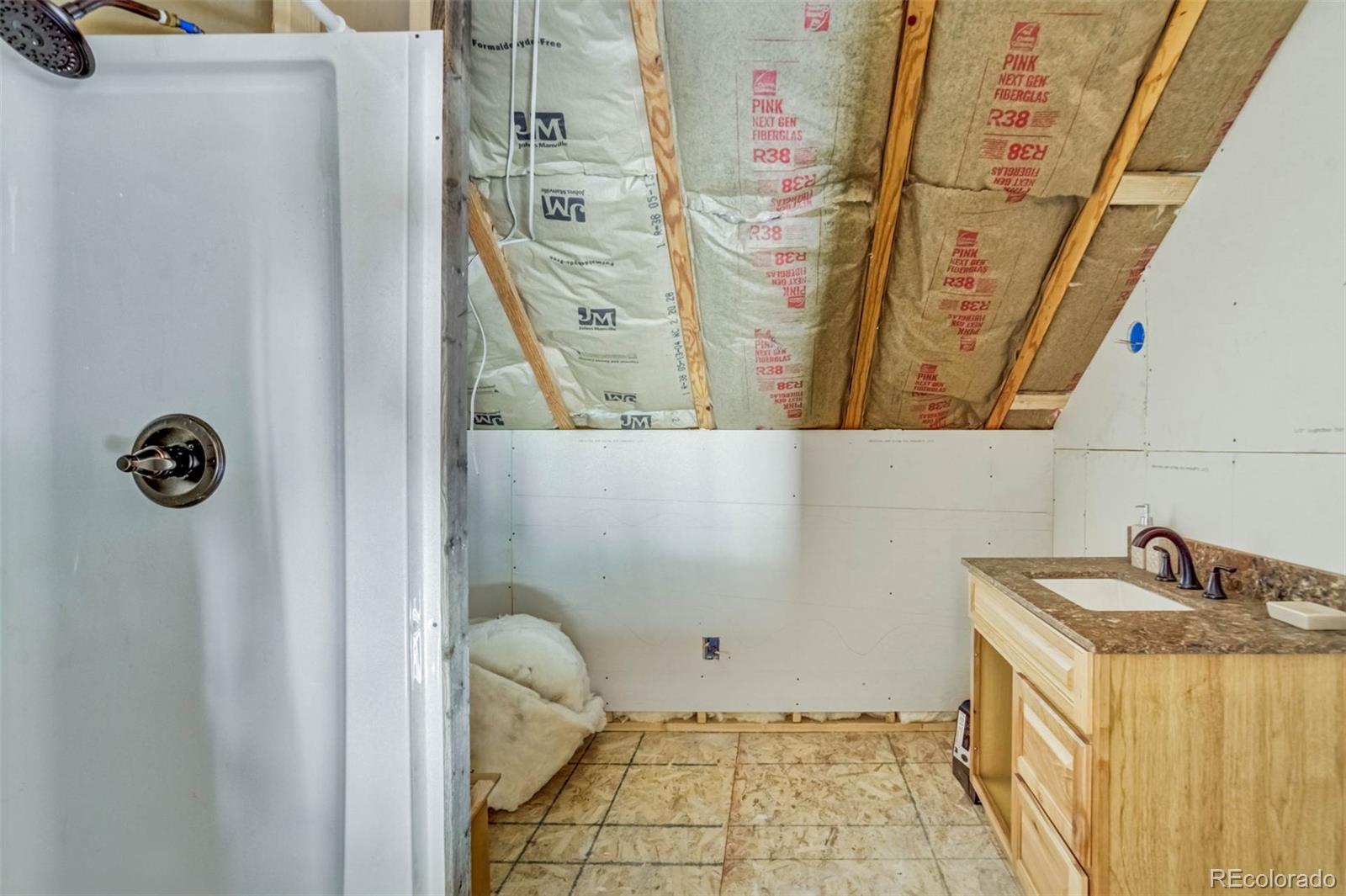 1440 North Range Road Guffey, CO 80820 - Photo 27 of 50 a bathroom with a granite countertop sink and a mirror