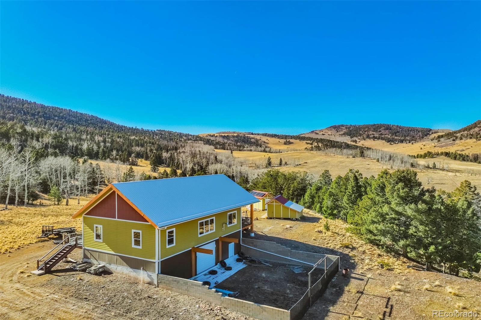 1440 North Range Road Guffey, CO 80820 - Photo 7 of 50 a view of a big house with a big yard and large trees