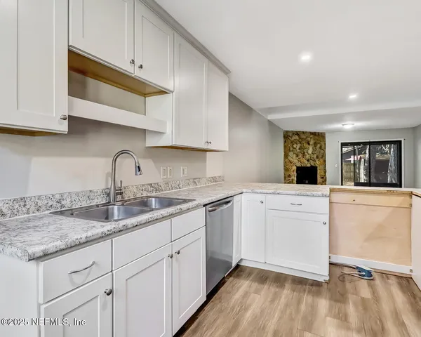 a kitchen with granite countertop white cabinets and white appliances