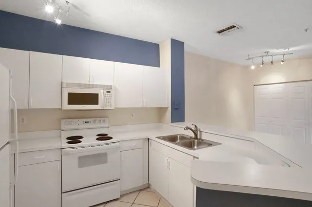 a kitchen with a sink a stove and cabinets