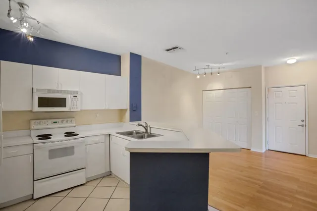 a kitchen with a sink cabinets and appliances