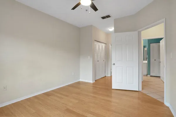 an empty room with a window and a ceiling fan