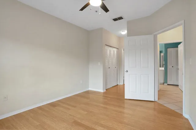 an empty room with a window and a ceiling fan