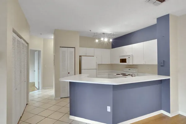 a kitchen with stainless steel appliances kitchen island a sink refrigerator and cabinets