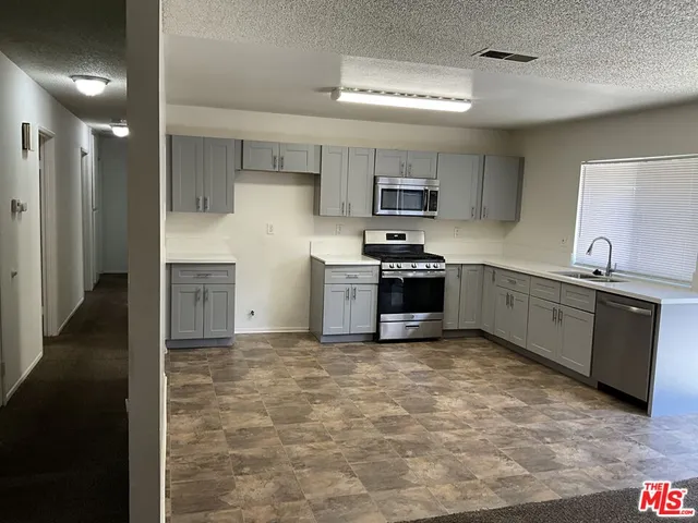 a kitchen with stainless steel appliances a sink stove and refrigerator