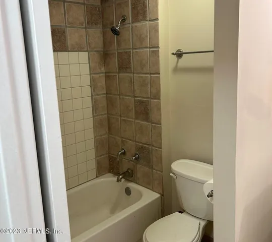 a white toilet sitting next to a bath tub