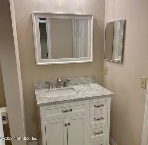 a bathroom with a granite countertop sink and a mirror