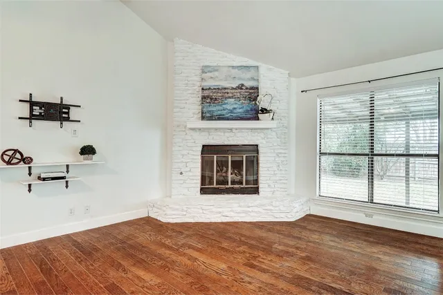 a view of a livingroom with a fireplace and window