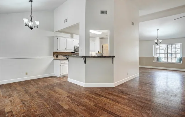 a view of a kitchen with wooden floor and a refrigerator