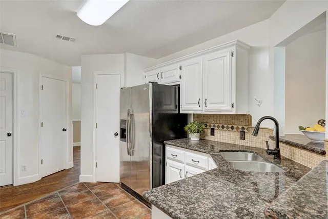 a kitchen with stainless steel appliances granite countertop a refrigerator and a sink